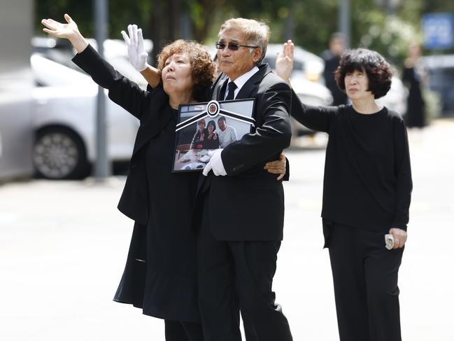 Steven Cho’s parents — Gum Ja Moon and Jong Yoon Cho (left) and Jung Hee Hong (mother of Min Cho) — wave goodbye as the coffins of Steven, Min and Benjamin Cho leave the Sydney Saesoon Presbyterian Church at North Rocks Picture: Richard Dobson