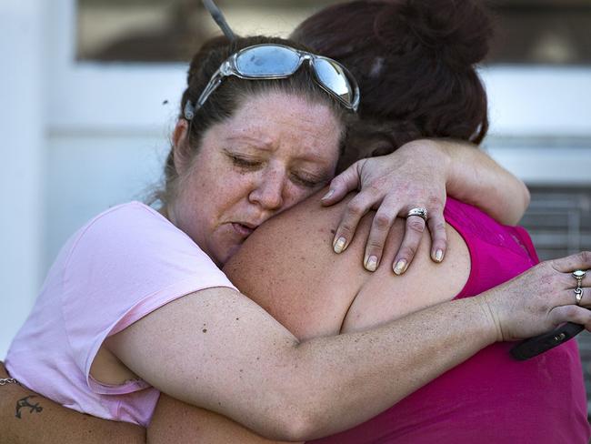 Witness Carrie Matula embraces a woman after the horror killing spree. Matula said she heard the shooting from the gas station where she works a block away. Picture: AP