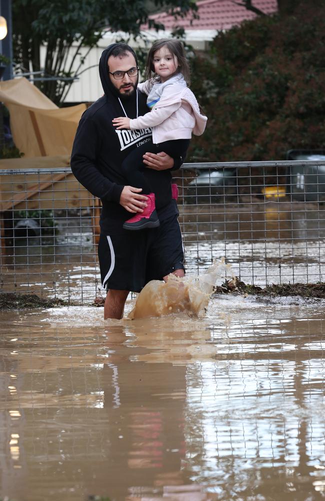 Shakespeare Street resident Anwar Eid carries his stepdaughter Rubi from their flooded unit near Traralgon Creek. Picture: David Caird