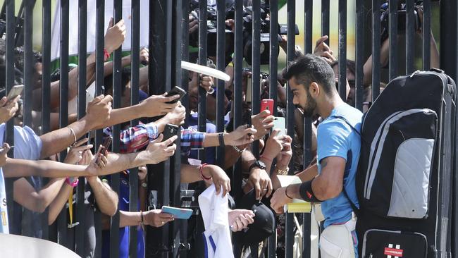 India's Virat Kohli signs autographs for fans at a gate of the Sydney Cricket Ground during training for the Cricket World Cup in Sydney, Australia, Wednesday, March 25, 2015. India will play Australia in the World Cup semifinal on Thursday March 26, 2015 to gain a place in the final against New Zealand.(AP Photo/Rob Griffith)
