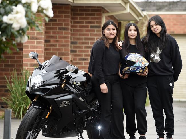 Kortney and Kaitlyn Tran and Francis Ta with a prized motorbike owned by Jonathan Tran, 22, who died in a fatal collision on Saturday on the Hume Freeway. Picture: Andrew Henshaw