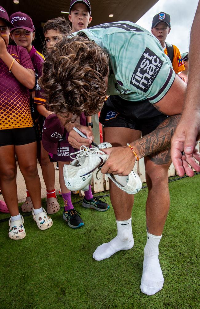 Reece signs his shoes before handing them over to six-year-old Mac. Picture: David Martinelli