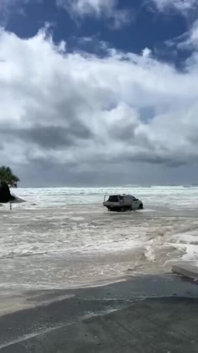 Ute pounded by waves on Currumbin beach, Gold Coast