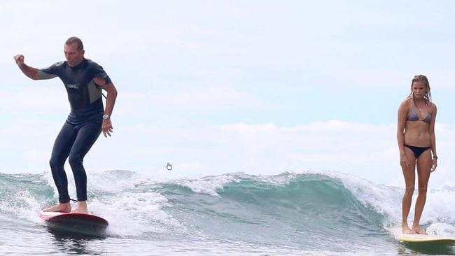 Tony Abbott in the water at Noosa with ‘stoked’ fellow surfer Ivy Thomas. PIC: Bailey Eldering/Instagram