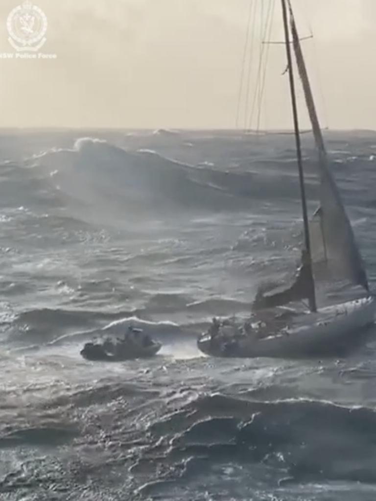 Rescuers reach a yacht with two people on-board in rough seas off the New South Wales south coast on Tuesday morning. Picture: NSW Police