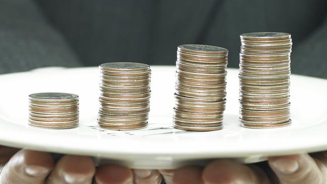 CAREERS: business concept/a businessman's hand holding a coin tower on a dish