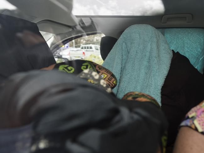 Renae Lawrence waits inside the  car with a towel over her head. Picture: Getty