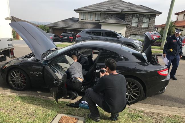 Police rip apart a Maserati sports car during the raid on the house in Poole Rd, Kellyville. Picture: John Grainger