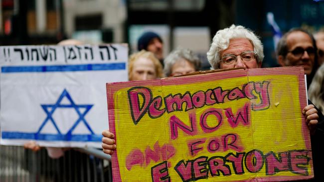 A protestor holds a sign reading "Democracy Now and for Everyone" as mass protests swept Israel.