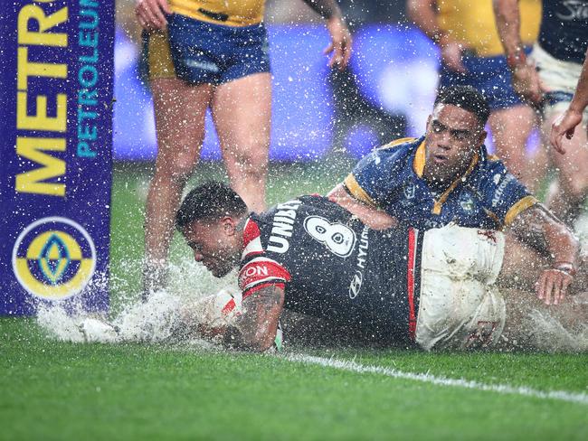 Water goes flying as Spencer Leniu crashes over to score a try. Picture: NRL Imagery