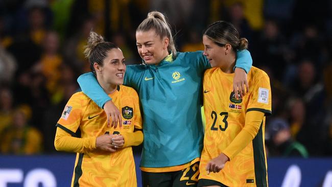 Australia's midfielder #19 Katrina Gorry (L), Australia's defender #22 Charlotte Grant and Australia's midfielder #23 Kyra Cooney-Cross (R) celebrate at the end of the Australia and New Zealand 2023 Women's World Cup round of 16 football match between Australia and Denmark at Stadium Australia in Sydney on August 7, 2023. (Photo by FRANCK FIFE / AFP)