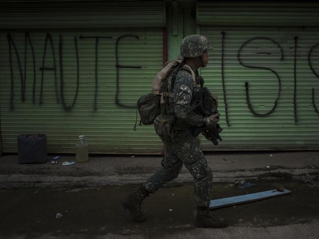 Philippine Marines soldiers in a cleared street but are still in range of enemy sniper fire as they walk towards the main battle area in Marawi. Picture: Getty