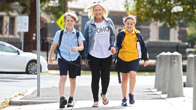 Vanessa Bell picks her children, Noah and Chloe, from St Mary's Primary School in Williamstown, Melbourne on the last day of the school term. Picture: Aaron Francis