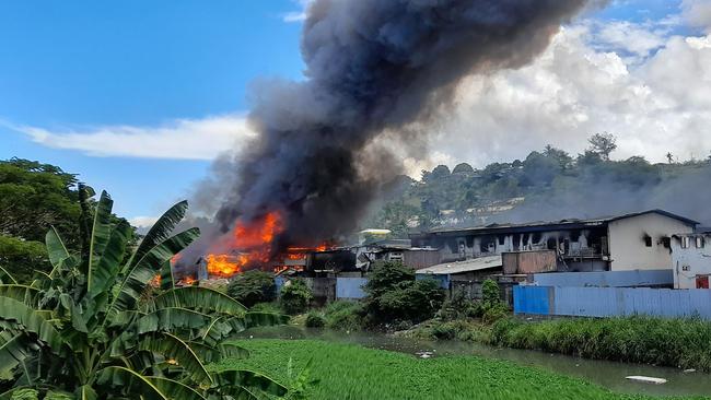 Flames rise from buildings in Honiara's Chinatown in November 2021 after days of rioting. Picture: AFP