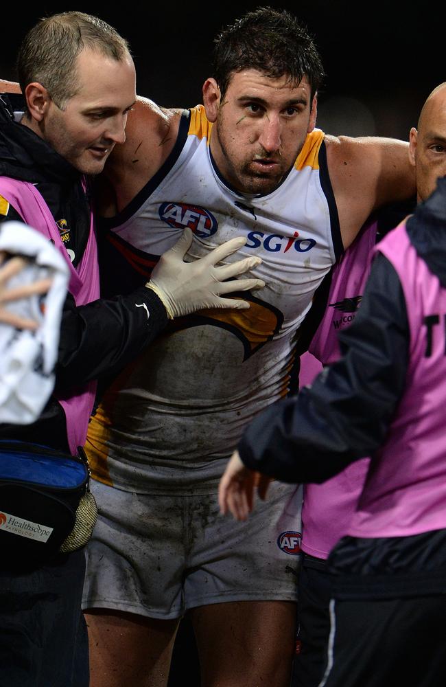 Eagle Dean Cox is helped from the ground. Picture: Daniel Wilkins