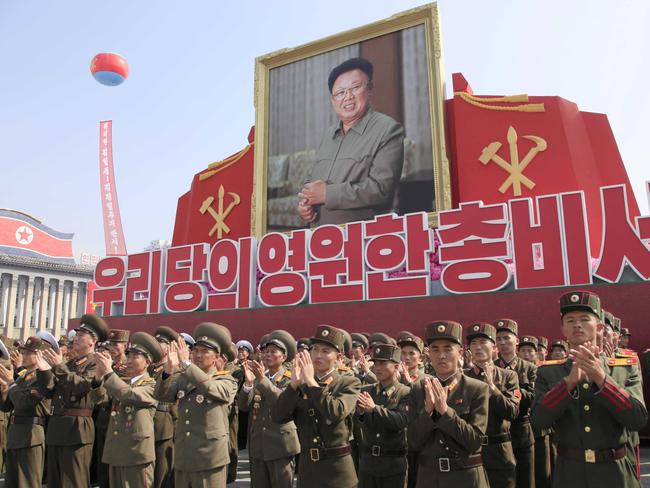 Soldiers applaud during an event marking the 20th anniversary of the election of former North Korean leader Kim Jong Il, in portrait, as general secretary of the Workers' Party, which is the founding and ruling party of North Korea. Picture: AP/Jon Chol Jin                        <a capiid="d2d0296ac1916279ecfcaed25ea4fab7" class="capi-video">President Trump's Doomsday Plane</a>