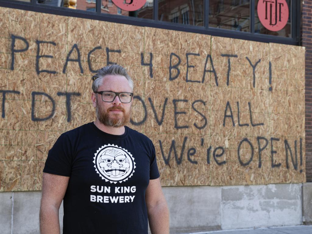 Restaurant owner Michael Cranfill poses in front of sign to honour his friend Chris Beaty. Picture: Michael Conroy/AP