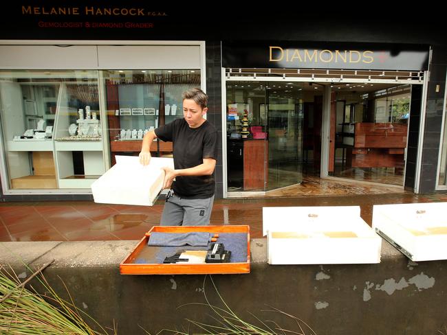 Anet Michel starts the clean-up at a jewellery store in Woodlark St. Picture: Nathan Edwards