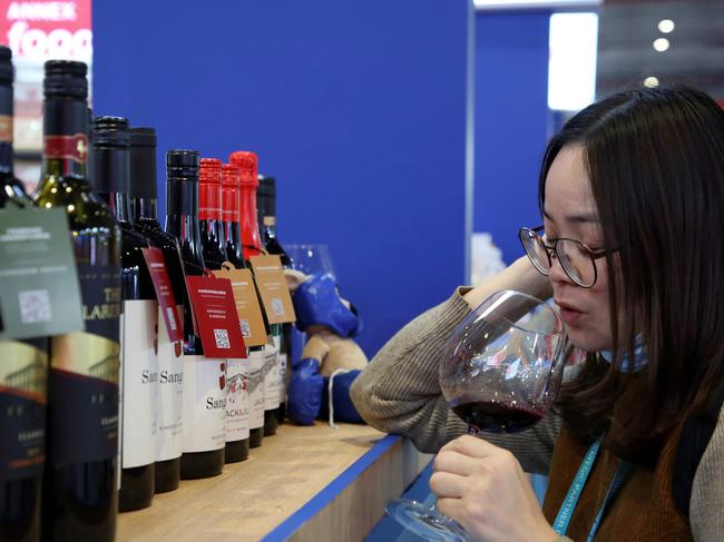 (FILES) This file photo taken on November 5, 2020 shows a woman tasting red wine from Australia at the Food and Agricultural Products exhibition at the third China International Import Expo (CIIE) in Shanghai . - China on December 10, 2020 said it had imposed fresh import duties on Australian wine as it accused Canberra of giving firms subsidies, in the latest salvo in a bitter stand-off following last month's swingeing anti-dumping tariffs. (Photo by STR / AFP) / China OUT