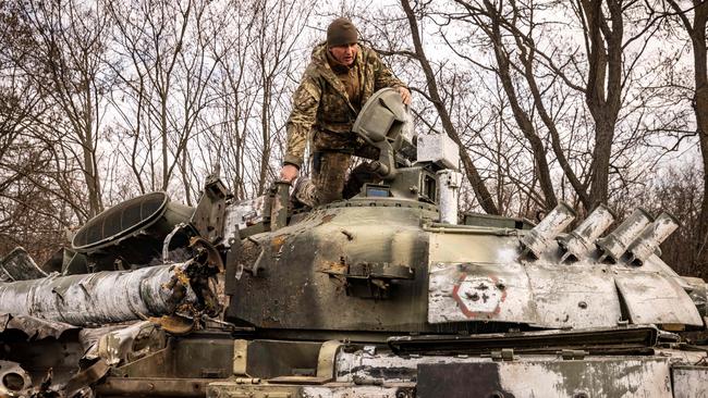 A Ukrainian serviceman inspects a damaged Russian tank. Picture: AFP