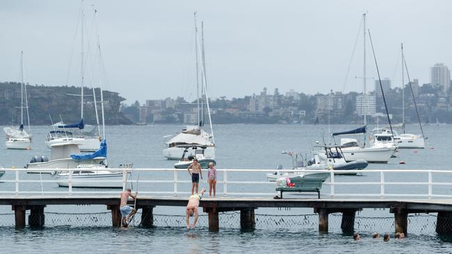 Swimmers dive off the jetty into the shark-safe enclosed swimming area. Picture: Max Mason-Hubers