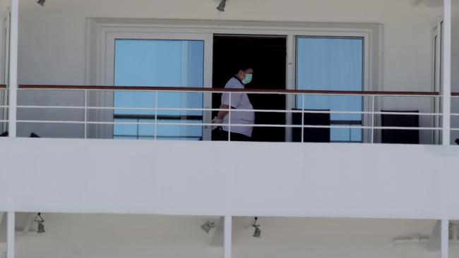 A passenger wears a mask on the MV Artania, which was supposed to leave Fremantle today. Picture: Colin Murty/The Australian