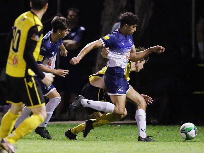 Tigers' Liam Bruce falls as he and Rangers' Michael Boctor battle for possession in the FNQ Football Premiership match between the Edge Hill Tigers and the Marlin Coast Rangers, held at Tiger Park, Manunda. Picture: Brendan Radke