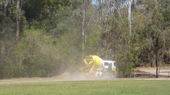 Dust plumes trail from a concrete mixer along the Toowong Creek corridor.