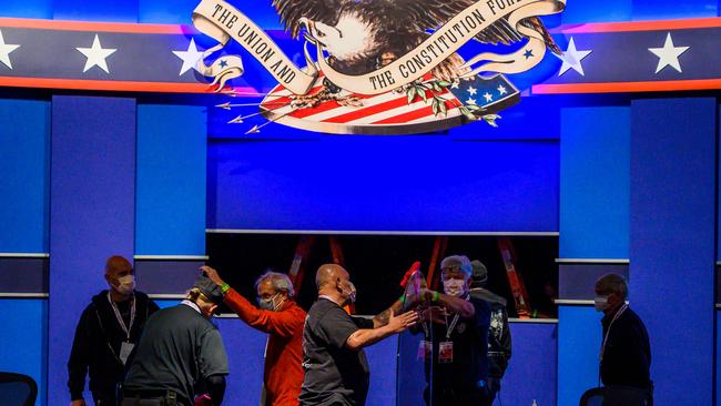 Workers install plexiglass protections on the stage of the debate hall ahead of the vice presidential debate in Kingsbury Hall of the University of Uta. Picture: Eric Baradat/AFP