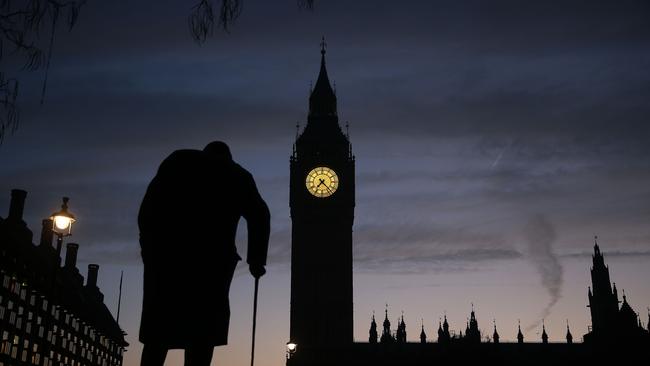 A statue of Winston Churchill is silhouetted by the Elizabeth Tower, more commonly known as "Big Ben", and the Houses of Parliament in central London.