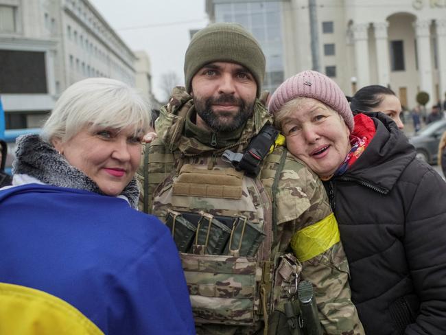 Local residents take a photo with Ukrainian serviceman as they celebrate after Russia's retreat from Kherson, in central Kherson, Ukraine November 12, 2022.  REUTERS/Lesko Kromplitz