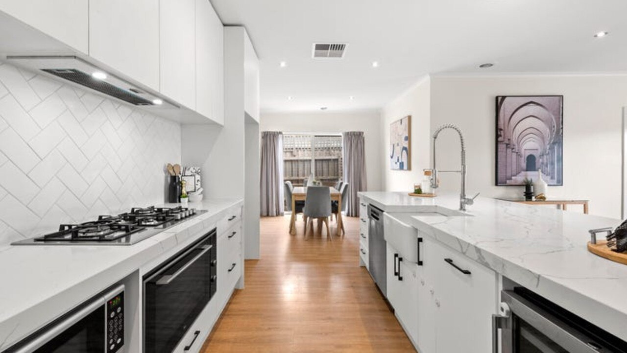 Stone benchtops, soft-close drawers, a ceramic sink, 900mm Teka appliances, a Bosch dishwasher and an island breakfast bench in the kitchen.