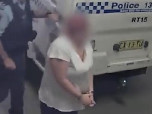 A woman, 26, being taken inside Raymond Terrace police station after being arrested over the screwdriver stabbing of a man on Donald Street, Nelson Bay on May 13, 2022. Picture: NSW Police.