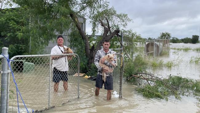 Brave Burketown residents including Chris Moren (left) and Mark Hocking (right) who remained after most residents were evacuated, rescued dogs left behind as the floods surged across the Gulf community. Picture: Supplied