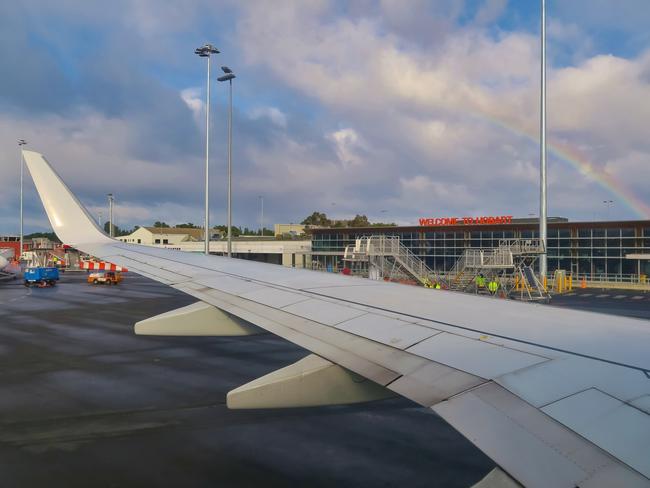 Airplane wing with rainbow. Hobart Airport building is in the background. Hobart, Tasmania, Australia. June 30, 2019. Yoav Daniel Bar-Ness. For TasWeekend.