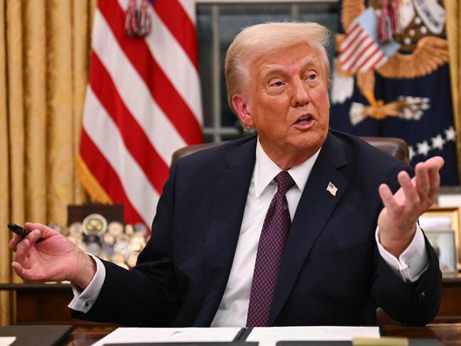 US President Donald Trump speaks to journalists as he signs an executive order regarding Department of Government Efficiency (DOGE), in the Oval Office of the White House in Washington, DC, on January 20, 2025. (Photo by Jim WATSON / POOL / AFP)