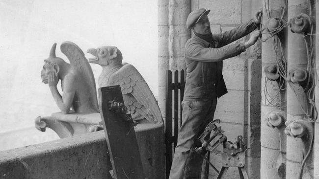 A workman on top of Notre Dame during earlier restoration works around 1900. Picture: getty Images