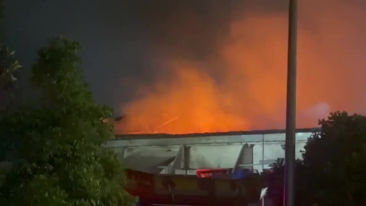 Flames leap through the roof of building in Qld tip blaze