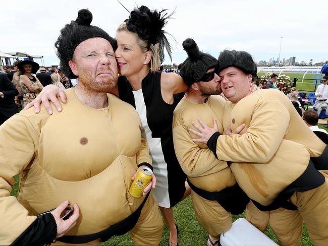 Colour – Melbourne Cup Day at Flemington Racecourse, Melbourne. Stacey Ciach kisses Sumo Owen while Peter and Mick wrestle. Picture: Tim Carrafa