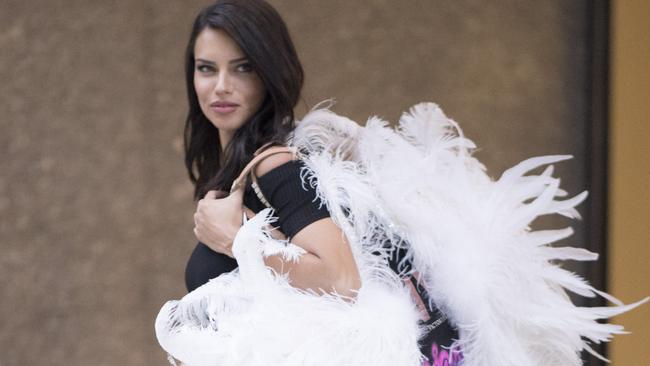 Adriana Lima clutching her ‘wings’ at a Victoria’s Secret fitting. Picture: Timur Emek/GC Images