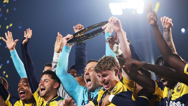 A jubilant Danny Vukovic (centre) lifts the A-League trophy amid Mariners celebrations. Picture: Mark Metcalfe/Getty Images