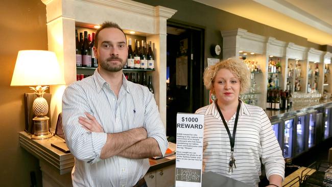 Peter Crocker and Leana Mynx of Hotel Mosman with the sign offering a $1000 reward for information leading to the capture and conviction of the “herpes” graffiti vandal. Picture: Adam Ward