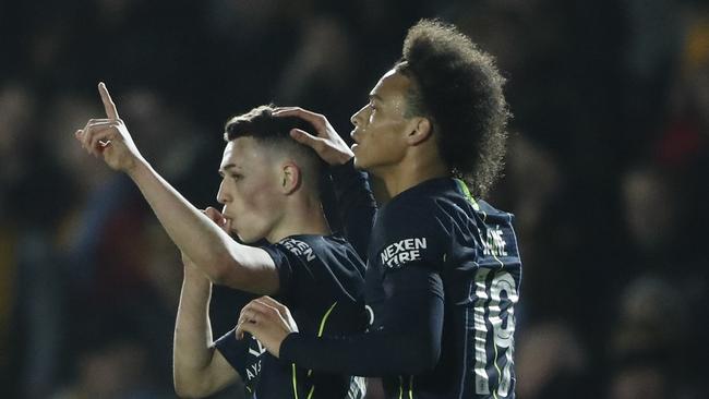 Manchester City's Phil Foden, left, celebrates with his teammate Leroy Sane after scoring his side's third goal. Picture: AP