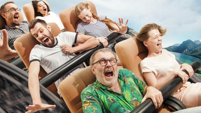 Speed doesn't stop, enjoy it. Emotional people on the roller coaster going down wih meadows on background. Caucasian men and women get adrenaline activity and having fun together on the rides.