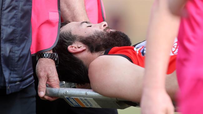 Myrtleford’s Rhys Grant is taken from the ground on a stretcher. Picture Yuri Kouzmin