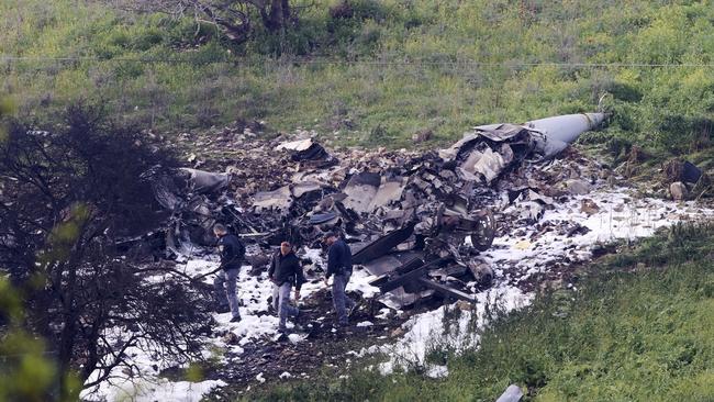 Israeli security oficers at the wreckage of an F-16 shot down by Syria in northern Israel on February 10.