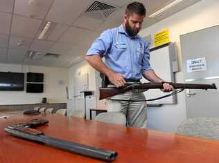 A Rural Crime Prevention Team officer inspects one of two firearms police recovered which were allegedly stolen from a New Italy property. Police are still seeking information about a further stolen firearm which has not been recovered. Picture: Marc Stapelberg