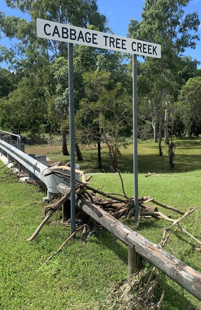 The floodwaters that tore through Cabbage Tree Creek Rd crossing had receded by Monday, leaving debris and branches.