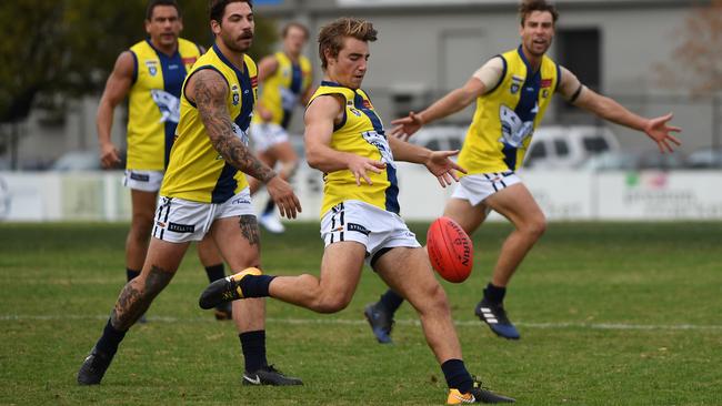 Sharks are everywhere as Michael Debenham boots the MPNFL forward against Northern on Saturday. Picture: James Ross