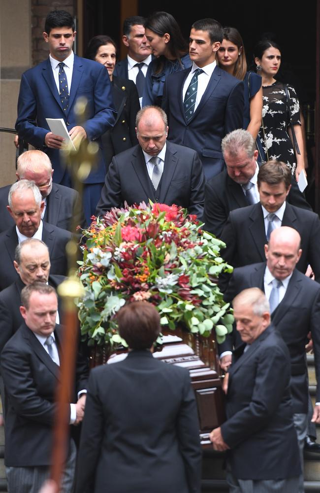 Family members follow the casket of the late Sir Nicholas Michael Shehadie covered in a native Australian flower arrangement at St James’ Church. Picture: Dean Lewins